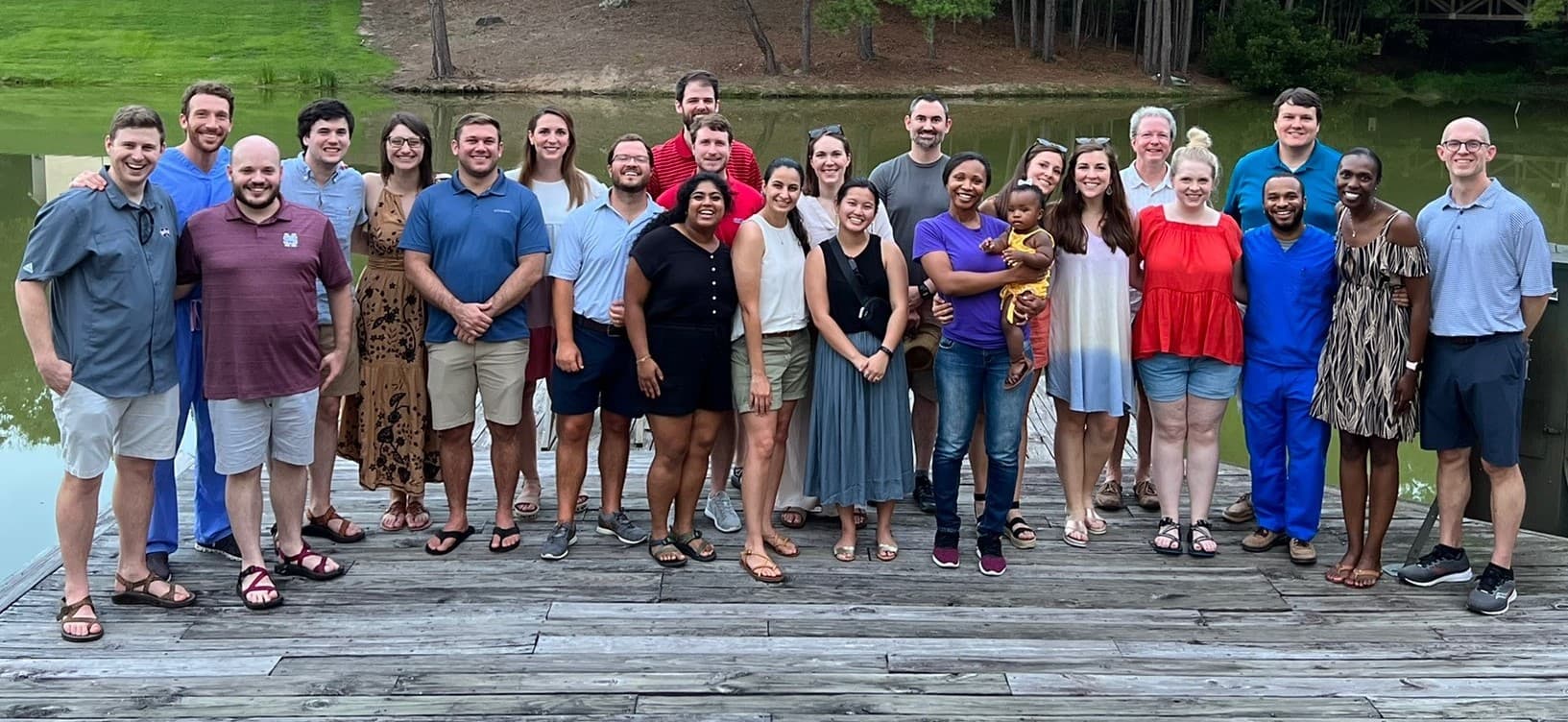 Group picture of Med-Peds students and faculty at dock with a lake in the background.